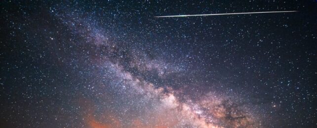 A meteor shooting across a starry night sky