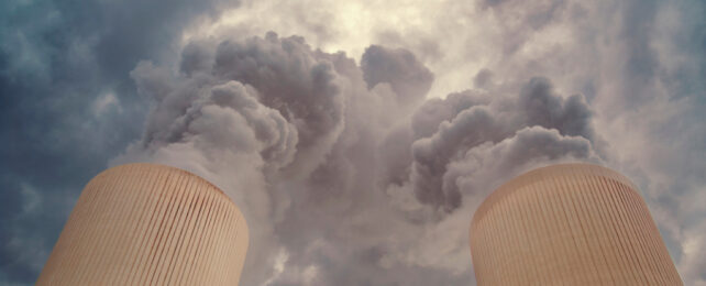 Two towers emitting steam into cloudy atmosphere.