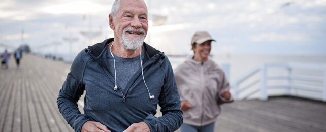 older people jogging along a pier