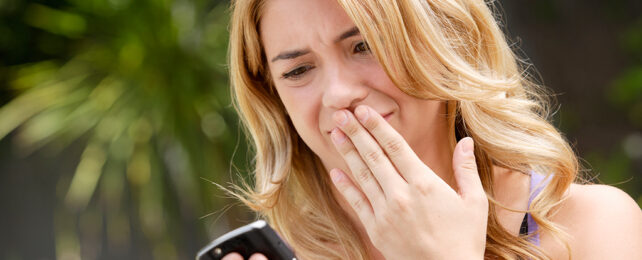 woman looking at her phone with a disgusted look on her face